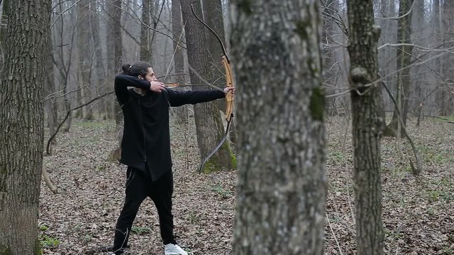 Man shoot with a bow in the forest