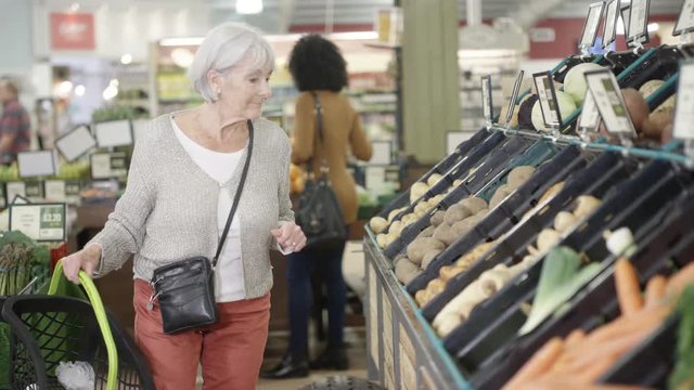  Cheerful senior lady shopping for groceries in the supermarket