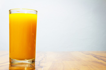 glass of orange juice on wooden table