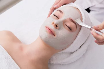 Foto auf Glas Woman gets face mask by beautician at spa © Prostock-studio