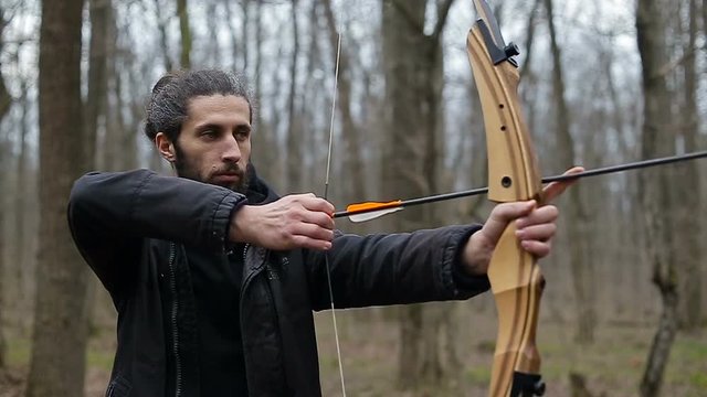 Man shoot with a bow in the forest