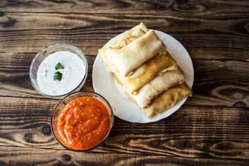 crepes with stuffing and white sauce and tomato