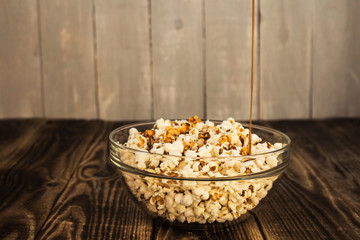 pouring caramel into bowl of popcorn