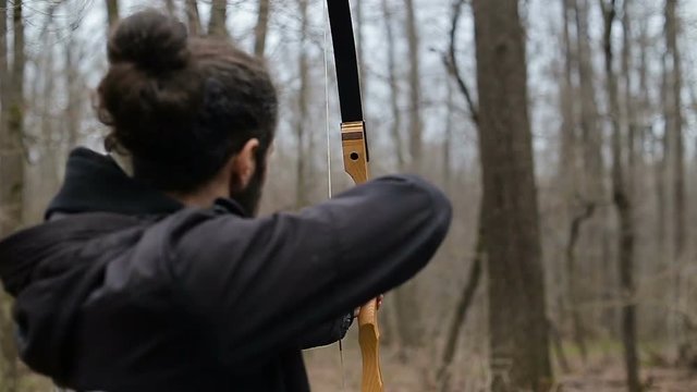 Man shoot with a bow in the forest