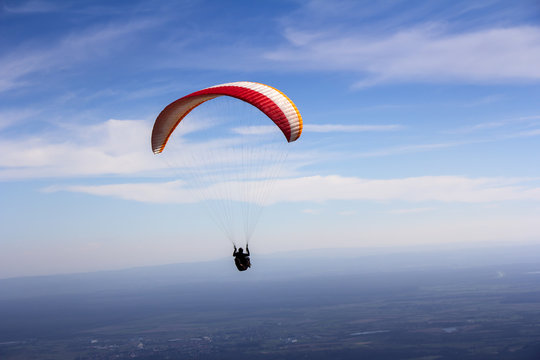 Paraglider flies in the blue summer sky