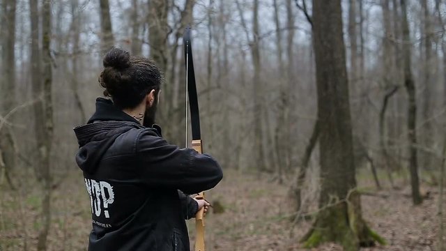 Man shoot with a bow in the forest