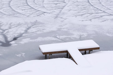 Snow covered dock on frozen lake