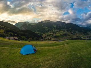 Blue tent in the campsite in Swiss Alps after sunset