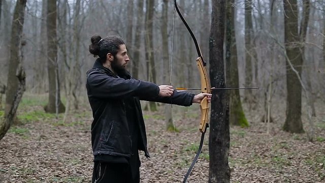 Man shoot with a bow in the forest