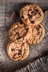 Chocolate cookies on dark  napkin on wooden table. Closeup of a group of assorted cookies..