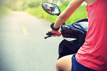 Young  woman traveling by a scooter on country road © lzf