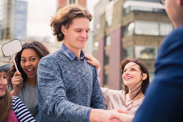 A group of young students, where two of them dispute and other support them during the break, outdoors