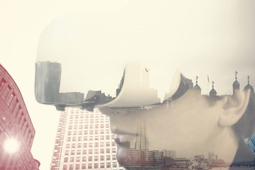 Double exposure of businessman with VR glasses over buildings skyscrapers and pollution chimney, future prediction concept   