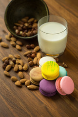 Tasty macaroons and cup of milk with almond on wooden background Selective focus.