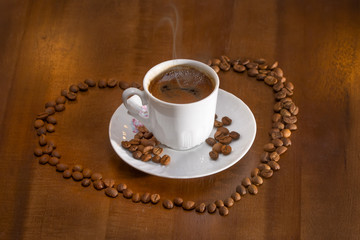 white cup hot coffee and scattered coffee grains