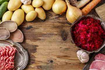 Different kinds of meat and vegetables on wooden table.