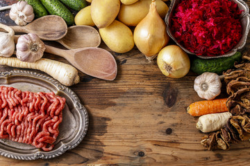 Different kinds of meat and vegetables on wooden table.