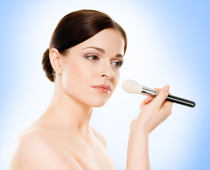 Portrait of young, beautiful and healthy woman: over blue background. Healthcare, spa, makeup and face lifting concept.