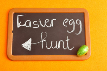 A blackboard with the words easter egg hunt and a green easter egg