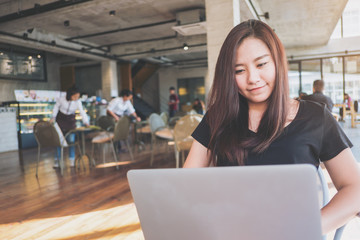 A woman sitting and using laptop in modern loft cafe