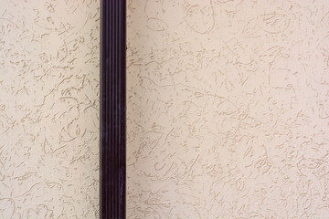 Close up downspout with beige wall surface