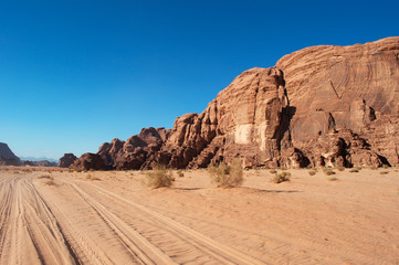 Fototapeta na wymiar Giordania, 2013/03/10: tracce di 4x4 nel deserto del Wadi Rum, la Valle della Luna simile al pianeta Marte, una valle scavata nella pietra arenaria e nelle rocce di granito