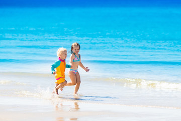 Naklejka premium Kids run and play on tropical beach