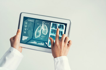 Close of female doctor hands working with tablet pc computer