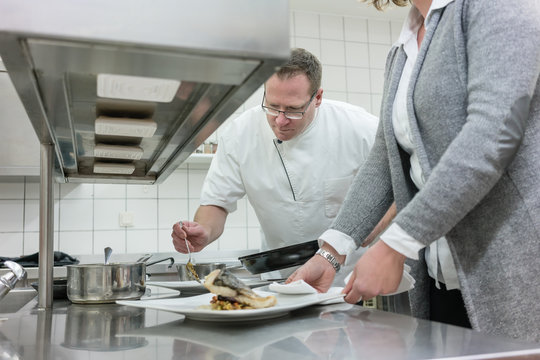 Service waitress and chef working together in restaurant kitchen - Powered by Adobe