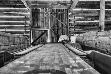 Old shuffleboard game and snowmobile in a barn