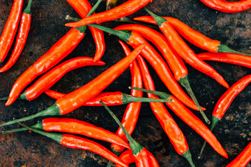 Red hot chili peppers over rustic surface - fresh and organic.