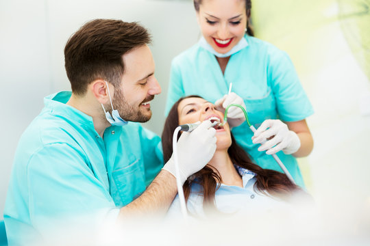 A dentist with assistant working on a patient