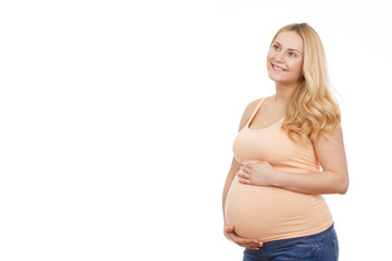 Dreaming about her baby. Horizontal studio portrait of a calm pregnant blonde female looking away dreamily smiling copyspace on the side isolated on white.