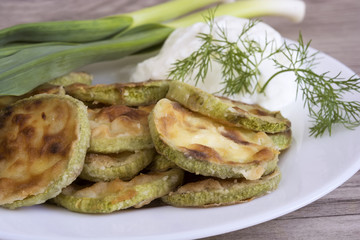 fried zucchini seasoned with dill and yogurt in a bowl