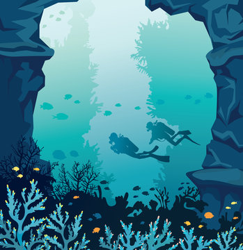 Scuba divers, coral reef, stone walls and blue sea.