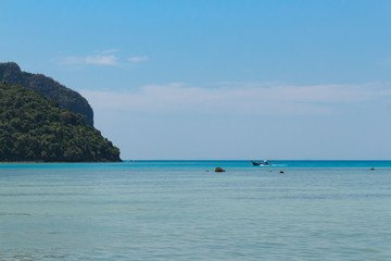 Fototapeta na wymiar Long Tail boat in Thailand cruising on cyan blue water