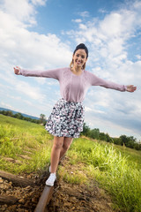 Beautiful young walking girl on the railway