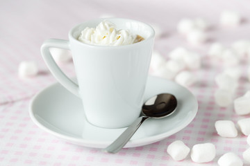 Cup of coffee or hot chocolate with whipped cream on the table at the cafe