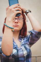 Fashion pretty young girl makes selfie portrait on smartphone.