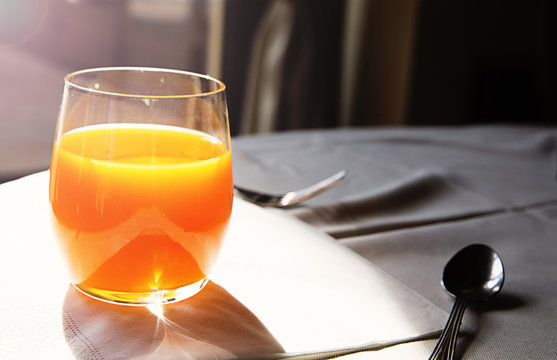 Glass of fresh orange juice and sunny morning