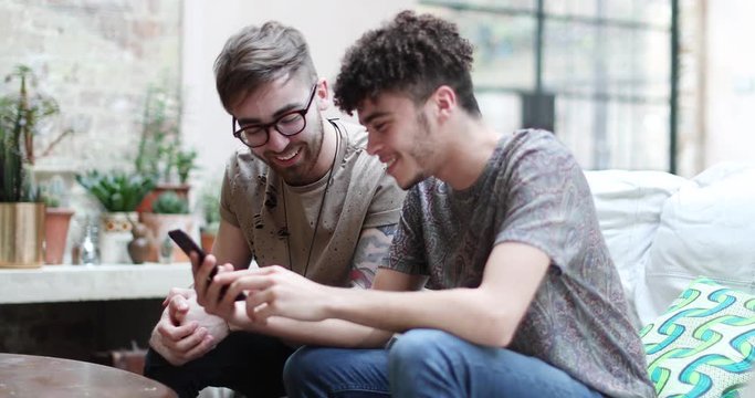 Two male friends looking at a smartphone