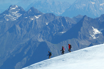 Fototapeta na wymiar Group of walking Tourists on the glacier with mountains on background