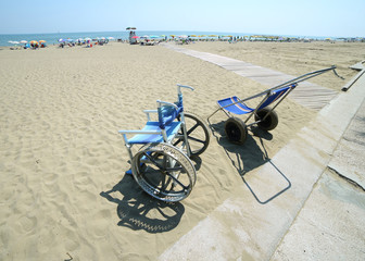 Fototapeta na wymiar special wheelchairs to go on the sandy beach to the sea