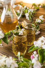 Apple juice in a glass with apple flowers on the table