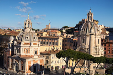 View to rooftops of Rome skyline with domes church Santa Maria di Loreto and dome church Nome di María , across from the Trajan's Column, near the Monument of Vittorio Emanuele at Piazza Venezia