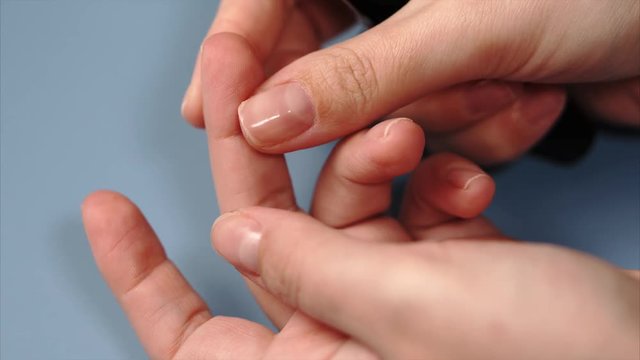 Close up blood sampling for glucometer on test strip. Female hand with drop of blood and test stripe for diabetes testing.