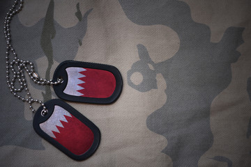 army blank, dog tag with flag of bahrain on the khaki texture background. military concept