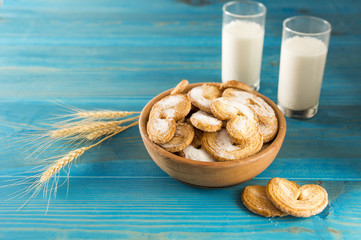 cookies and milk near the spikelets of wheat on the table