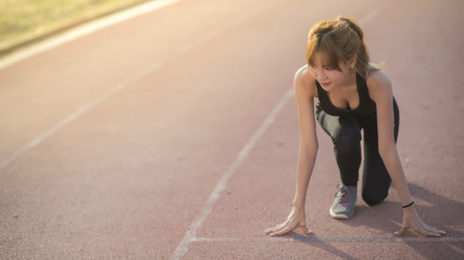 Fit and confident woman in starting position ready for running