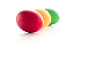 Multicolored easter eggs, on a white wooden background. The concept of a holiday and a happy Easter. With space for text